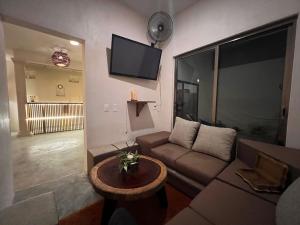 a living room with a couch and a tv on the wall at Casa bix a beel. in Tulum