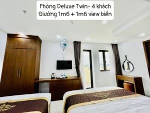 1 dormitorio con 2 camas y TV. en TRUNG KIÊN HOTEL en Ha Long