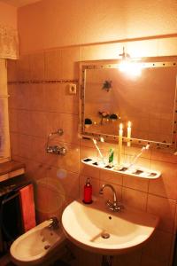 a bathroom with a sink and a mirror with candles at Haus Prilblume in Detern