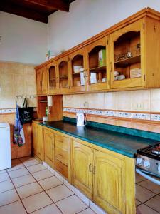 eine Küche mit Holzschränken und einer schwarzen Arbeitsplatte in der Unterkunft Casa Tribu in Huaraz