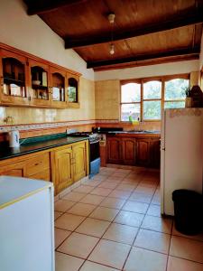 cocina con armarios de madera y nevera blanca en Casa Tribu, en Huaraz