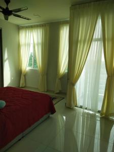 a bedroom with a red bed and large windows at AVA Homestay Kuala Terengganu Pantai Drawbridge in Kuala Terengganu