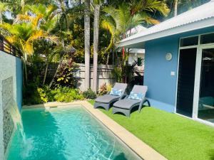 - une piscine avec 2 chaises et une maison dans l'établissement Hanalei Port Douglas - Private Pool, à Port Douglas