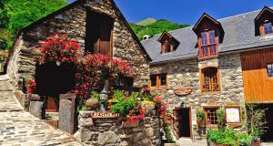 ViscosにあるHôtel La Grange Aux Marmottesの花の古い石造りの建物