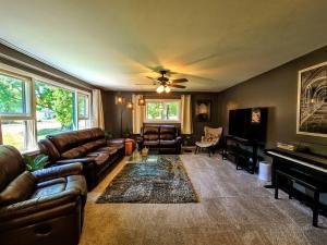 a living room with leather couches and a piano at Ultra Comfy, Spotless & Spacious, Private Home in Boyne, Dogs Ok, Walk to Town in Boyne City +38 photos