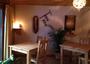 un comedor con 2 mesas de madera y una planta en Chambre d'Hôtes La Trace, en La Clusaz