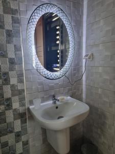 y baño con lavabo blanco y espejo. en Hammamet vue mer, en Hammamet
