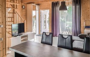 a dining room with a table and chairs and a television at Nice Home In Sianozety With Wifi in Sianozety