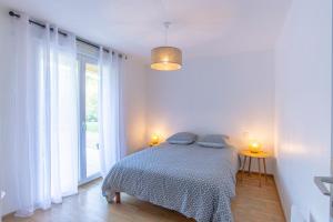 a bedroom with a bed with two lamps on it at Superbe appartement avec terrasse et vue dégagée in Monteils
