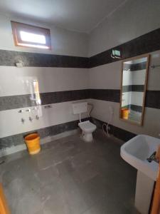 a bathroom with a toilet and a sink at Odyssey Stays Rathuadhab (Jim Corbett National Park) in Badīyārgaon