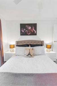 um quarto com uma cama branca e 2 candeeiros em Sleepy Shackell - Echuca Moama Holiday Accommodation em Echuca