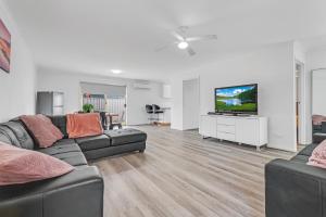エチューカにあるSleepy Shackell - Echuca Moama Holiday Accommodationのソファと薄型テレビのあるリビングルーム
