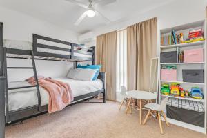a bedroom with bunk beds and a table and chairs at Sleepy Shackell - Echuca Moama Holiday Accommodation in Echuca