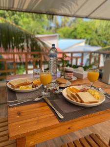 una mesa con dos platos de comida y dos vasos de zumo de naranja en Bougainvillea Inn - Maldives, en Fulidhoo