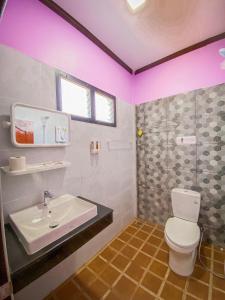 a bathroom with a white toilet and a sink at Baan Rung Tawan in Ban Bang Nao