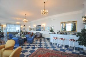 a lobby with a waiting room with chairs and a bar at Hotel Belvedere in Conca dei Marini