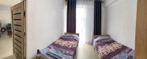 1 dormitorio con 2 camas y espejo en Apartment Paris Resort Issyk-Kul, en Chok-Tal