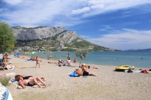 a group of people laying on a beach at Apartments with a parking space Duce, Omis - 4650 in Duće