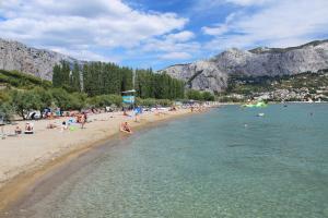 a group of people on a beach in the water at Apartments with a parking space Duce, Omis - 4650 in Duće
