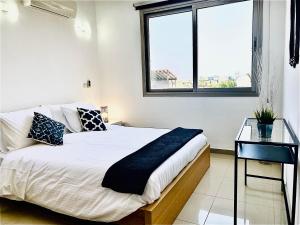 ein weißes Schlafzimmer mit einem Bett und einem Glastisch in der Unterkunft The Penthouse 401 in Larnaka