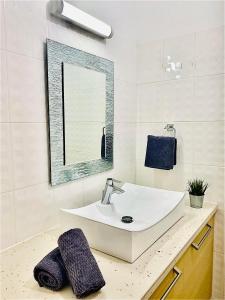ein Bad mit einem Waschbecken und einem Spiegel in der Unterkunft The Penthouse 401 in Larnaka