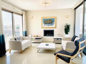 a living room with white furniture and a tv at The Penthouse 401 in Larnaca