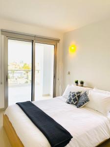 ein Schlafzimmer mit einem großen Bett und einem großen Fenster in der Unterkunft The Penthouse 401 in Larnaka