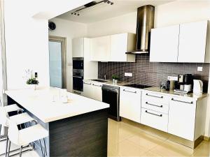 eine Küche mit weißen Schränken und schwarzen Geräten in der Unterkunft The Penthouse 401 in Larnaka