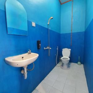 Baño azul con lavabo y aseo en Candi Panggung Family Guest House Syariah, en Malang