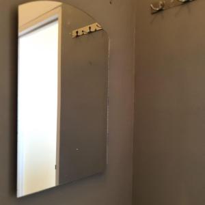 a mirror hanging on a wall in a bathroom at Candi Panggung Family Guest House Syariah in Malang