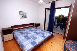 a bedroom with a bed and a sliding glass door at Apartments by the sea Sumpetar, Omis - 4827 in Jesenice
