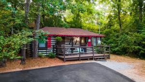 une cabine dans les bois avec un toit rouge dans l'établissement Log Cabin Motor Court, à Asheville