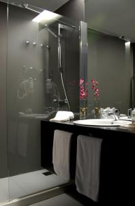 a bathroom with a shower and a sink with towels at Quinta De Casaldronho Wine Hotel in Lamego