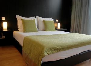 un grande letto in una camera d'albergo con due lampade di Quinta De Casaldronho Wine Hotel a Lamego