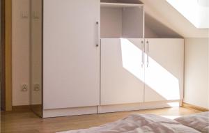 a bedroom with a large white cabinet with a window at Nice Apartment In Grzybowo With Kitchenette in Grzybowo