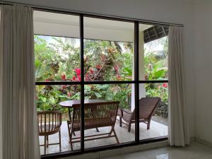 een kamer met een groot raam met een tafel en stoelen bij Wonder-Land Villa in Ubud