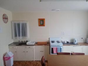 a kitchen with a stove and a sink at The Crooked Cottage in Murtoa
