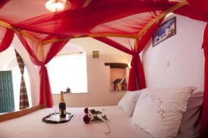 1 dormitorio con 1 cama con dosel rojo en Something Else, en Agia Anna de Naxos