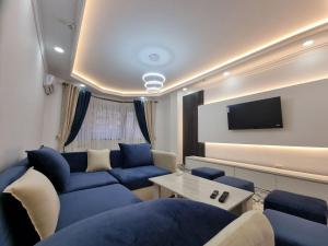 ein Wohnzimmer mit blauen Sofas und einem TV in der Unterkunft Квартира в аренду Tashkent in Taschkent