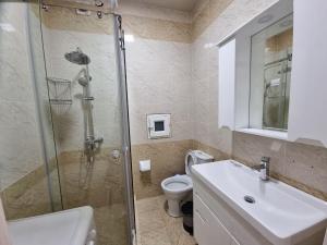 ein Bad mit einer Dusche, einem Waschbecken und einem WC in der Unterkunft Квартира в аренду Tashkent in Taschkent