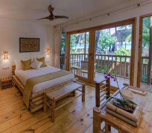 a bedroom with a bed and a balcony at Ecoboo Maldives in Thinadhoo