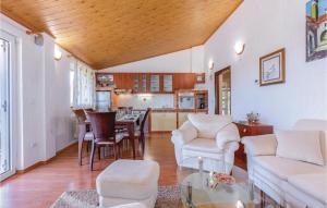 ein Wohnzimmer mit einem Tisch und Stühlen sowie eine Küche in der Unterkunft Lovely Home In Donji Zagon With House Sea View in Donji Zagon