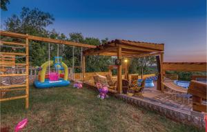 einen Hinterhof mit einem Spielplatz mit Rutschen und einem Pool in der Unterkunft Lovely Home In Donji Zagon With House Sea View in Donji Zagon