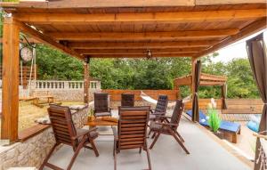 a patio with a wooden pergola and a table and chairs at Pet Friendly Home In Donji Zagon in Donji Zagon
