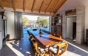 une salle à manger avec une table en bois et une grande fenêtre dans l'établissement Stunning Home In Metkovic With House A Panoramic View, à Metković