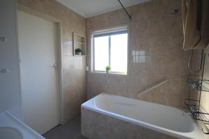 a bathroom with a bath tub and a window at Phillip Island Park Lane Holiday Park in Cowes