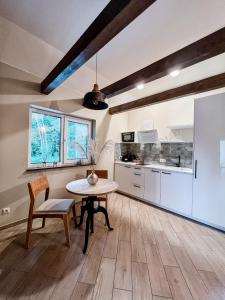 a kitchen and dining room with a table and chairs at Amber House Deluxe in Agluonėnai