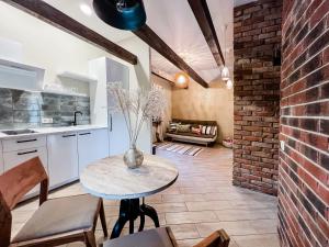 a kitchen with a table and a brick wall at Amber House Deluxe in Agluonėnai +9 photos