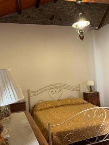 1 dormitorio con cama, lámpara y mesa en La casetta in collina, en Reggio Calabria