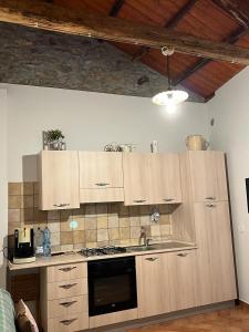 cocina con armarios de madera y horno con fogones en La casetta in collina, en Reggio Calabria